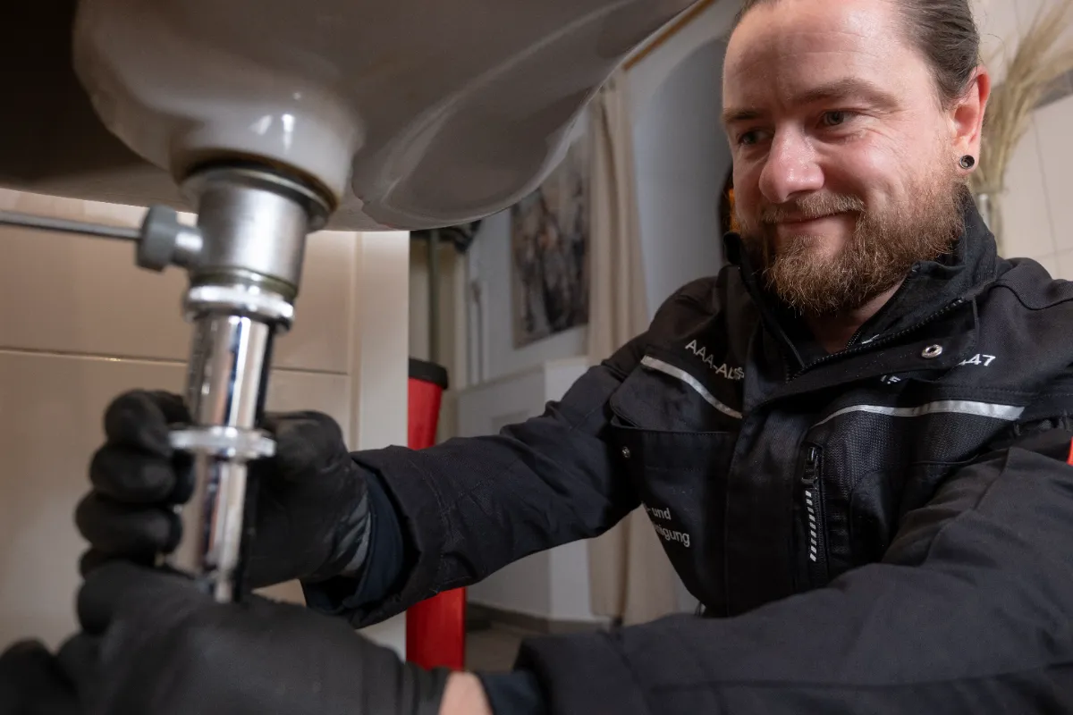 Besorgter Hausbesitzer spricht mit Techniker über Wasserschaden durch verstopftes Rohr